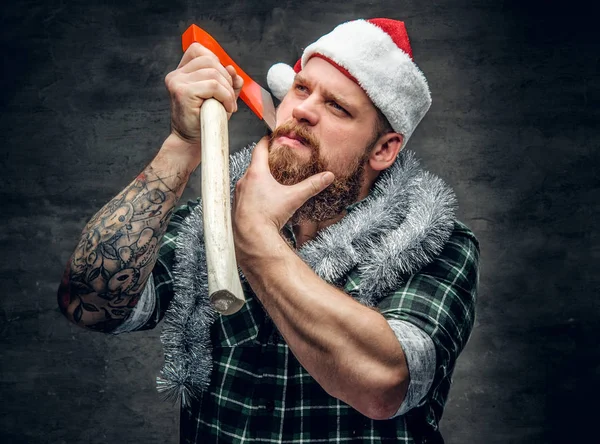 Man in Santa's hat holding axe — Stock Photo, Image
