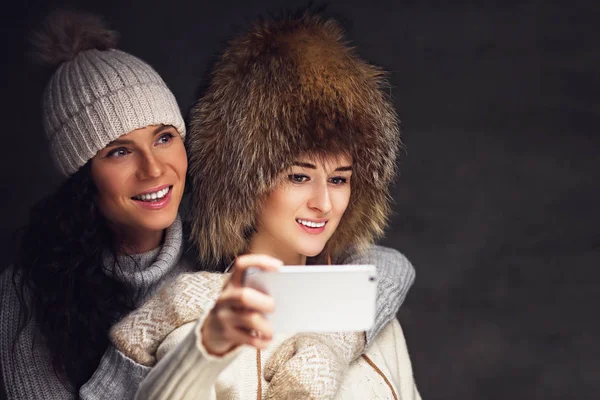 Duas mulheres fazendo selfie com smartphone . — Fotografia de Stock