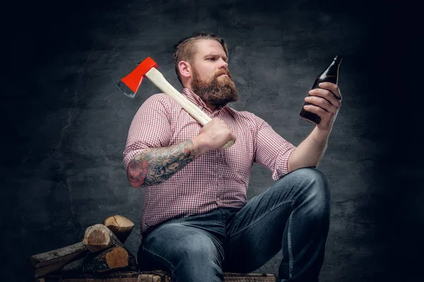 Hombre gordo sosteniendo un hacha y una botella de cerveza —  Fotos de Stock