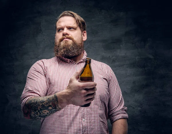 Uomo barbuto in possesso di bottiglia di birra — Foto Stock