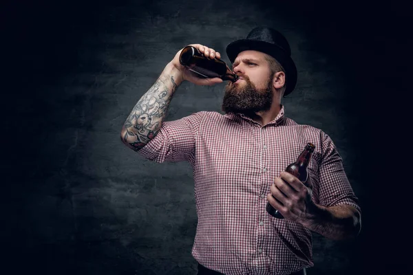Homem barbudo bebendo cerveja de uma garrafa . — Fotografia de Stock