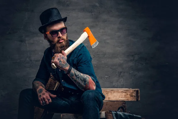 Man with tattooed arms holding an axe — Stock Photo, Image