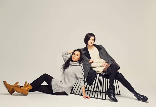 Två attraktiva brunett kvinnor poserar i en studio. — Stockfoto