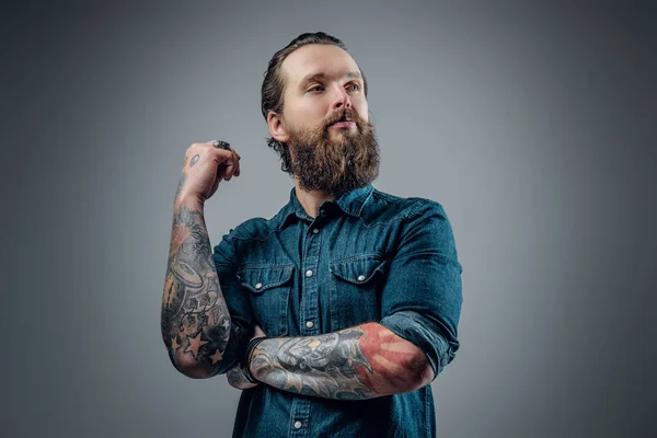 Skäggig man med tattooes på armarna — Stockfoto