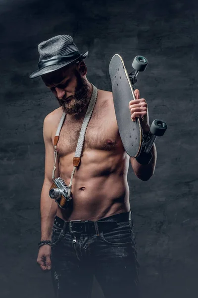 Uomo senza maglietta con skateboard e macchina fotografica — Foto Stock