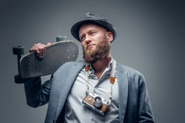 Mannen innehar skateboard och foto kamera — Stockfoto