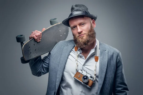 Homem segurando skate e câmera de fotos — Fotografia de Stock