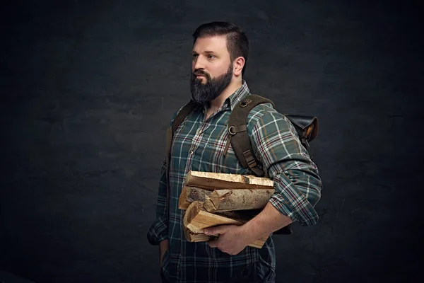 Hombre sosteniendo mochila y leña —  Fotos de Stock