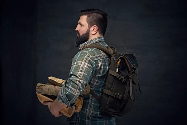 Homem segurando mochila e lenha — Fotografia de Stock