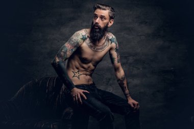 sakallı adam bir sandalyede oturuyor