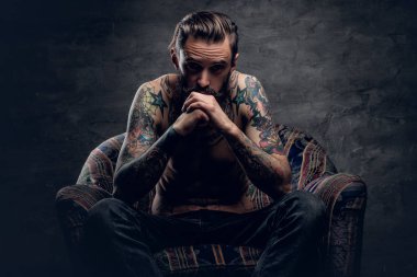 sakallı adam bir sandalyede oturuyor