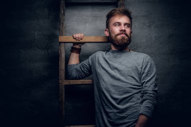 Sakallı adam eski merdiveni poz.