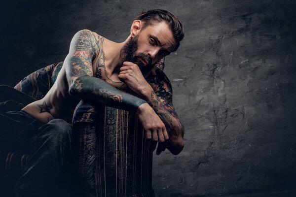 Сидящий на стуле бородатый мужчина
