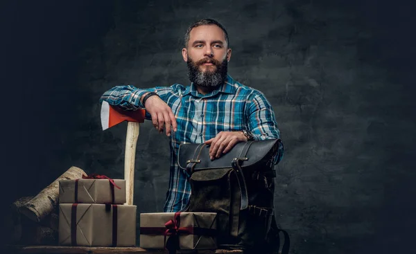 Людина з різдвяними подарунковими коробками і дровами — стокове фото