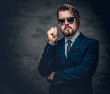 Sakallı adam bir takım elbise ve güneş gözlüğü