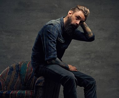 Dövmeli yenilikçi bir sandalyeye poz