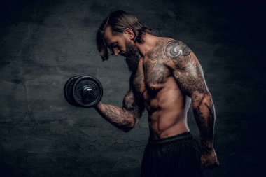 Dövmeli vücut dumbbell tutarak adamla