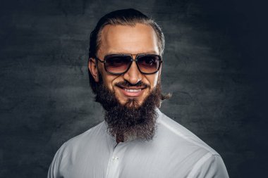 Sakallı adam beyaz bir gömlek ve güneş gözlüğü