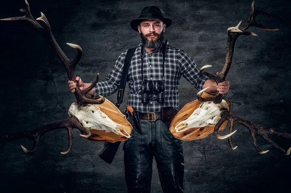 Hunter man holding a deer skulls