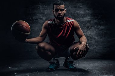 Çömelme ve topu tutan basketbolcu