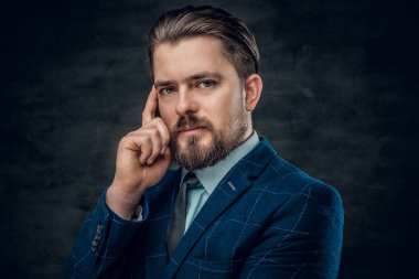 Sakallı adam bir takım elbise ve kravat giyiyor