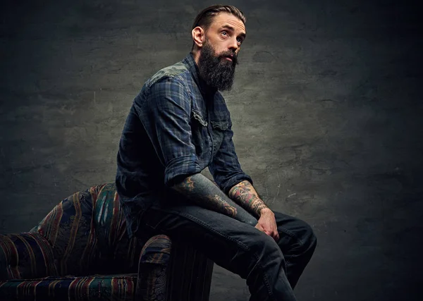 Stylish hipster posing on a chair — Stock Photo, Image