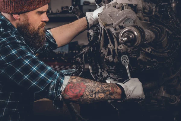 Бородатий чоловік ремонтує двигун автомобіля — стокове фото