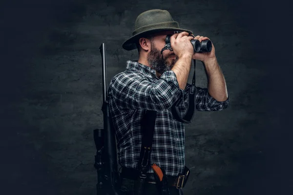 Hunter segurando uma espingarda e binóculos — Fotografia de Stock