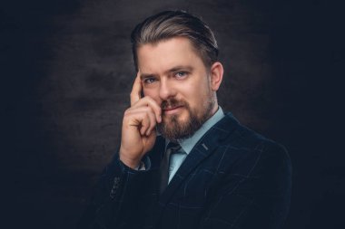 Sakallı adam bir takım elbise ve kravat giyiyor