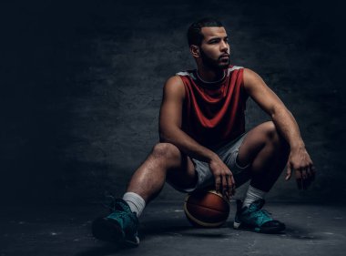 Sepet topu üzerinde oturan basketbolcu