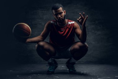 Çömelme ve topu tutan basketbolcu