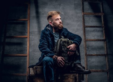 Bir ahşap kutu backpacker oturur