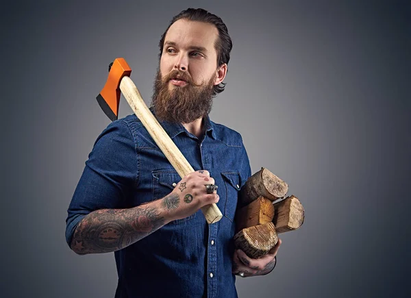 Homem barbudo segura machado e lenha . — Fotografia de Stock