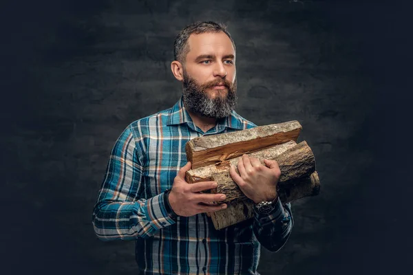 Bearded man holds firewoods — Stock Photo, Image