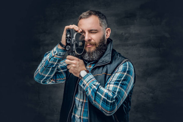 Bearded man holds video camera