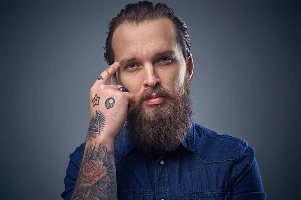 Бородатый мужчина с татуировками на руке — стоковое фото