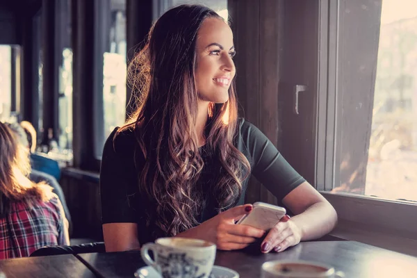 Vrouw die een smartphone gebruikt in een café — Stockfoto