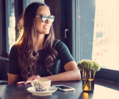 Gülümseyen bir kafede esmer kadın