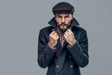 Yenilikçi bir gri ceket ve kap giymiş