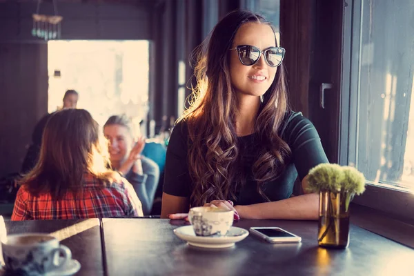 Usměvavá brunetka žena v kavárně — Stock fotografie