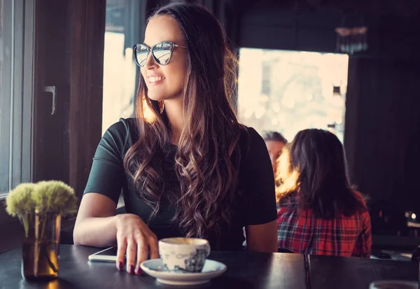 Lachende brunette vrouw in een café — Stockfoto