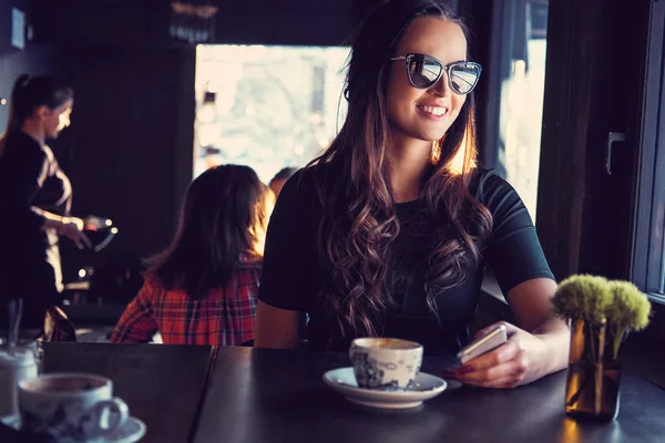Smiling brunette woman in a cafe — Stock Photo, Image