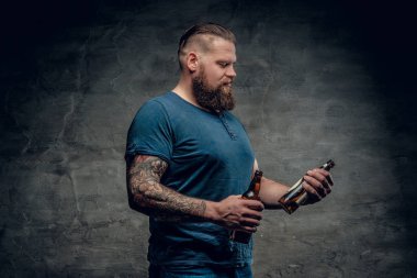 Sakallı adam bira şişeleri tutar