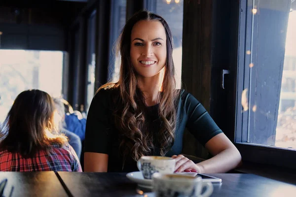 Brunette vrouw in een café — Stockfoto