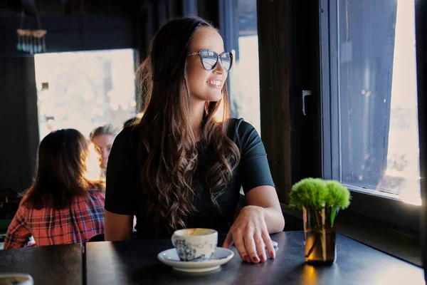 Usměvavá brunetka žena v kavárně — Stock fotografie