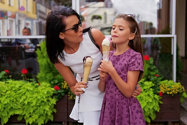 Brunett kvinna och flicka äter glass — Stockfoto