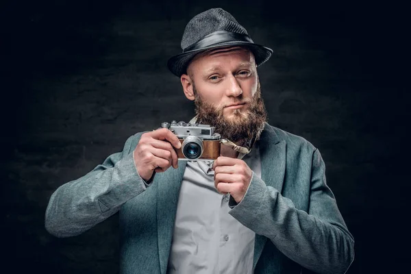 Uomo barbuto tiene fotocamera fotografica — Foto Stock