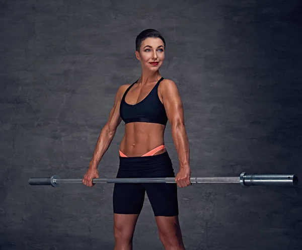 Sporty female holds barbell. — Stock Photo, Image