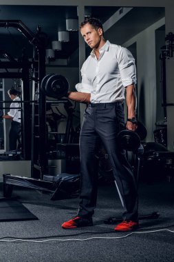 Şık adam dumbbells tutar