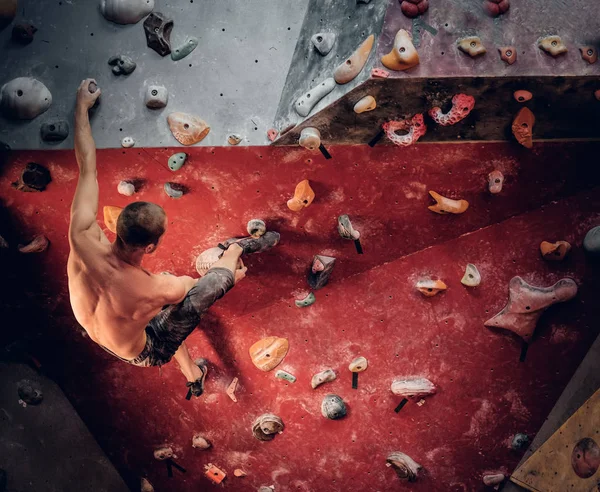 Athletic man climbing wall — Stock Photo, Image